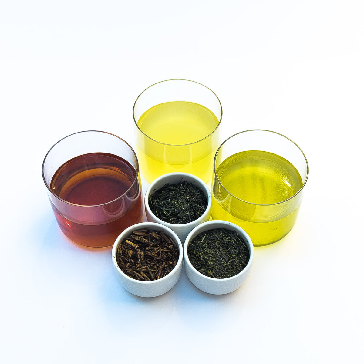 Trois varietes de thés japonais infuses, avec feuilles seches presentees a cote